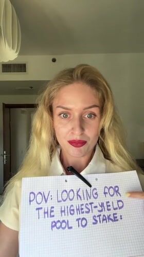 Woman uses magnifying glass in cryptocurrency staking demonstration