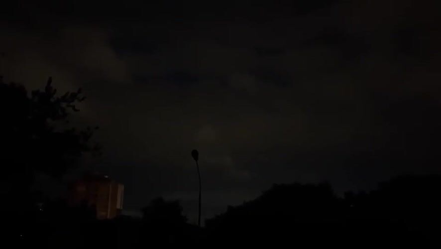 Crescent moon and park lights on a cloudy Minsk night
