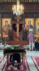 Person prays in Tsarevo church amid religious iconography