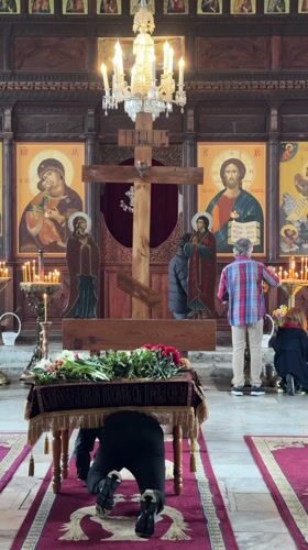 Person prays in Tsarevo church amid religious iconography