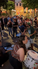 Street drummers and dancers draw a crowd at dusk