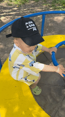Toddler plays on playground carousel in Rusanovo, Russia