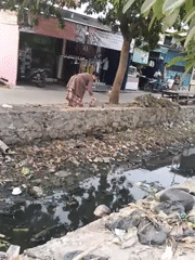 Belimbing street life amid heavy traffic and visible urban waste