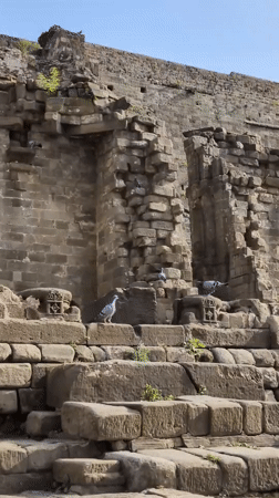 Tourist documents ancient stone ruins and fort structures in Kaswara