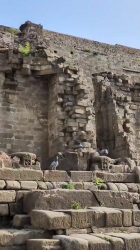 Tourist documents ancient stone ruins and fort structures in Kaswara