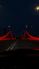 Nighttime drive across Moscow's red-lit suspension bridge